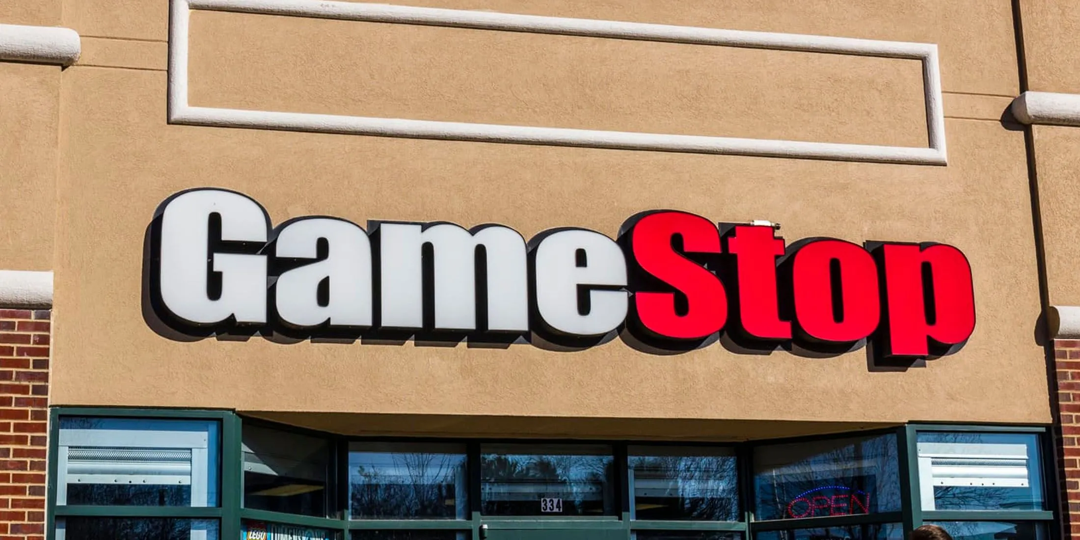 Chiến Lược Mới Của GameStop: Thẻ Bài Game Có Phải Cứu Cánh Giúp Báo Lãi Sau 6 Năm? 1 Hình ảnh minh họa cửa hàng GameStop và concept thay thế bởi đối thủ cạnh tranh PayMore, liên quan đến việc đóng cửa hàng và nhượng lại địa điểm
