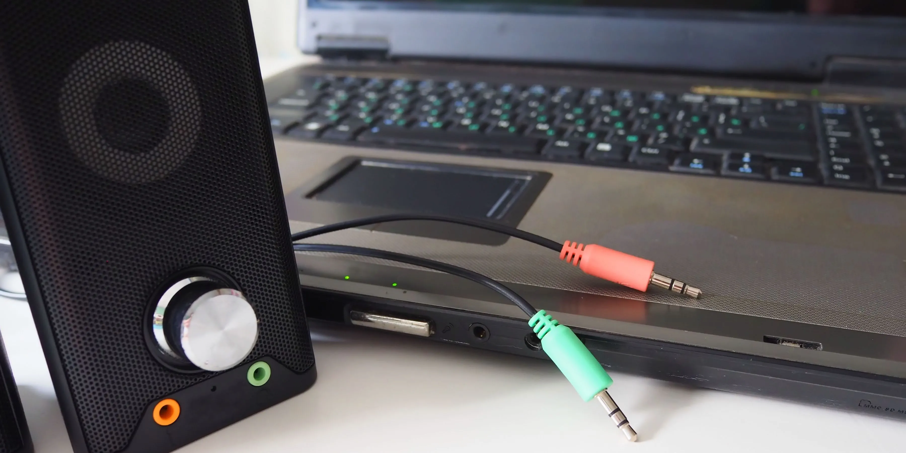 Hình ảnh một chiếc loa máy tính với nhiều dây cáp audio 3.5mm kết nối với PC, minh họa thách thức quản lý dây nhợ lằng nhằng trên bộ máy PC gaming.