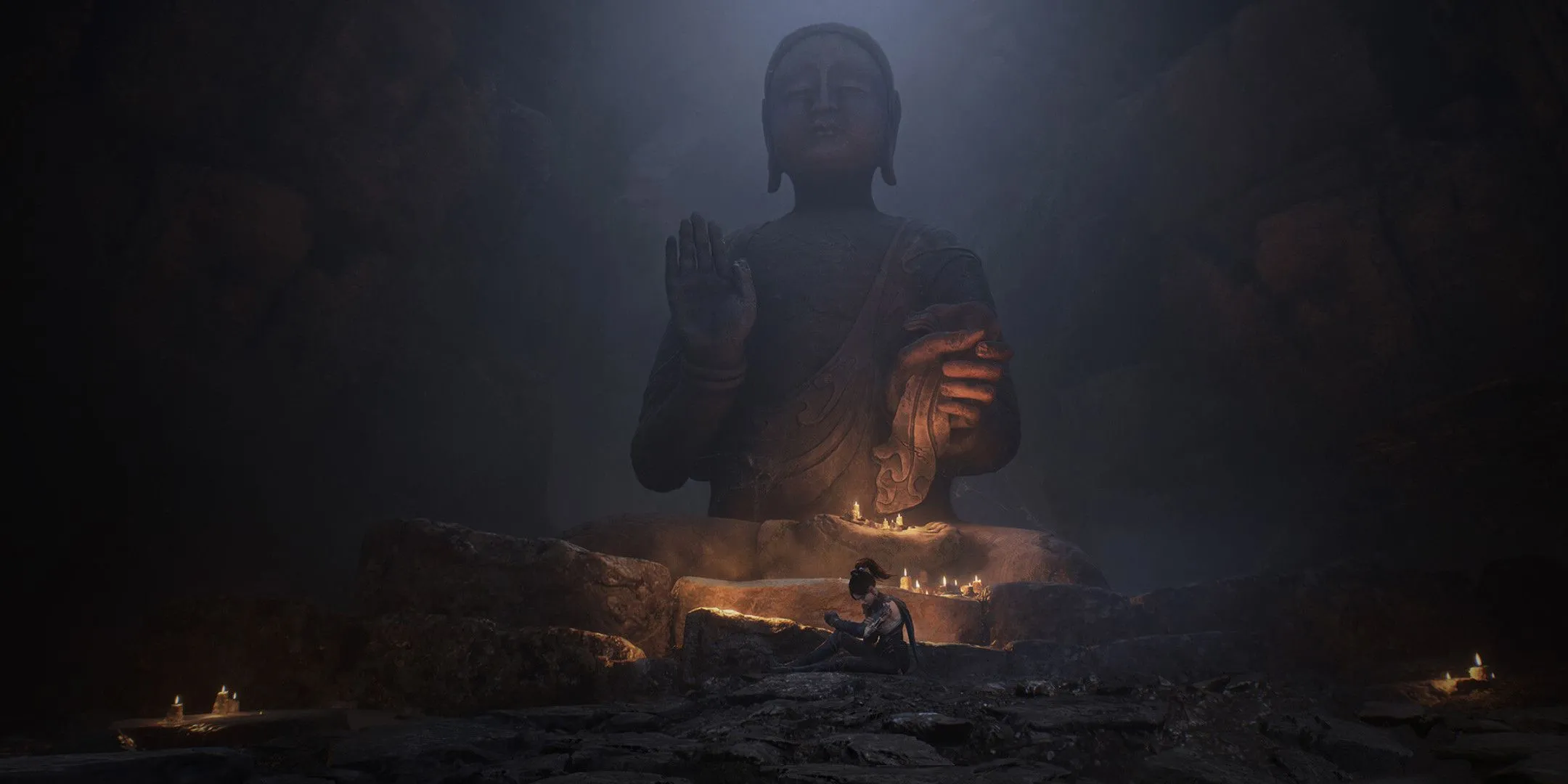 Nhân vật chính của Wuchang: Fallen Feathers đang ngồi tĩnh lặng dưới một bức tượng Phật khổng lồ, tạo nên không gian linh thiêng và suy tư.